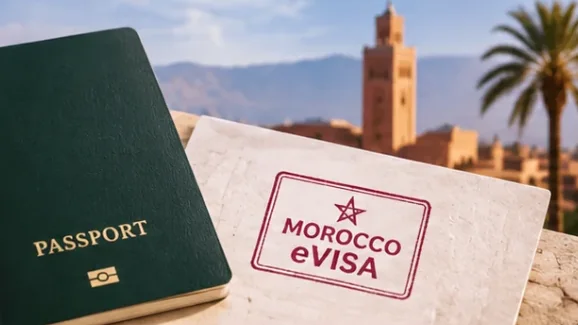 Passport with a Morocco eVisa stamp in front of the Koutoubia minaret in Marrakech